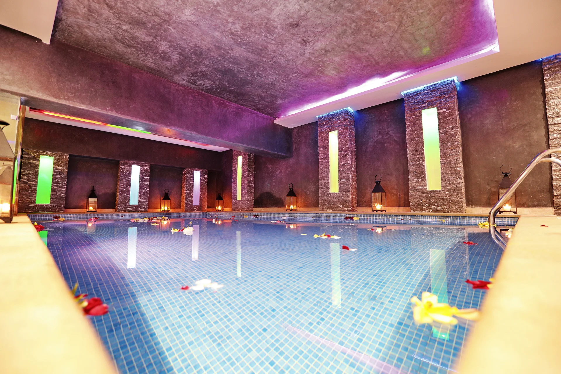 Piscine couverte du spa Orélia, eau bleue et lanternes au bord de la piscine